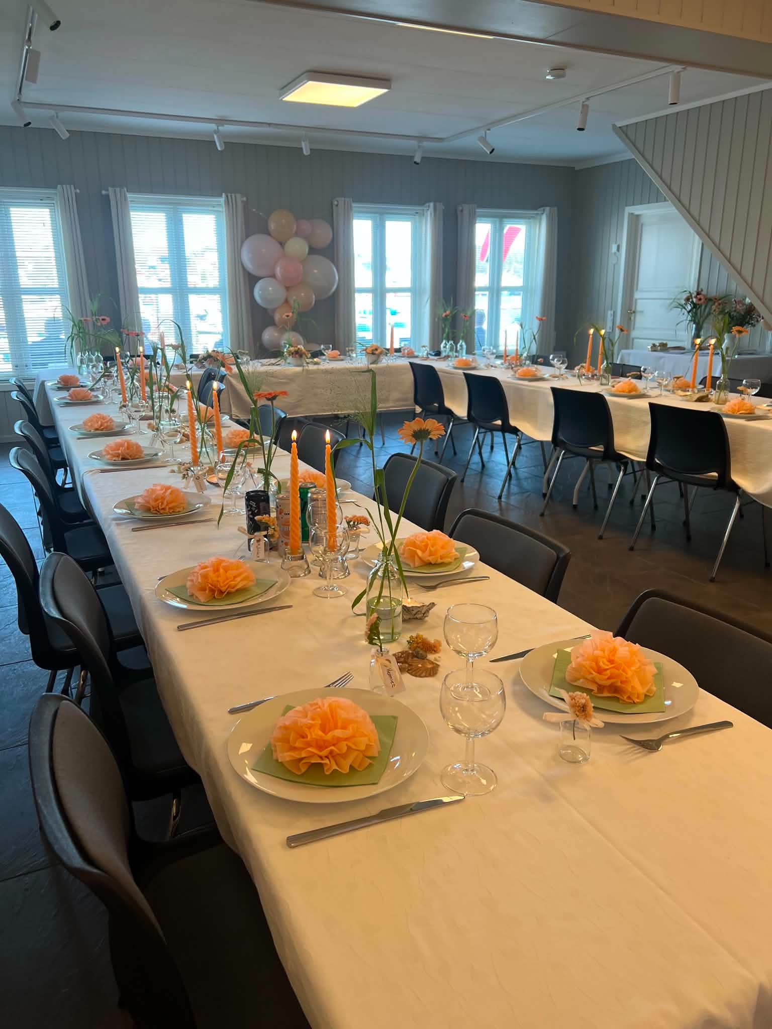 Storsalen med langbord dekket til selskap